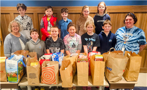  K-Kids Club members and advisors pose with their food donations